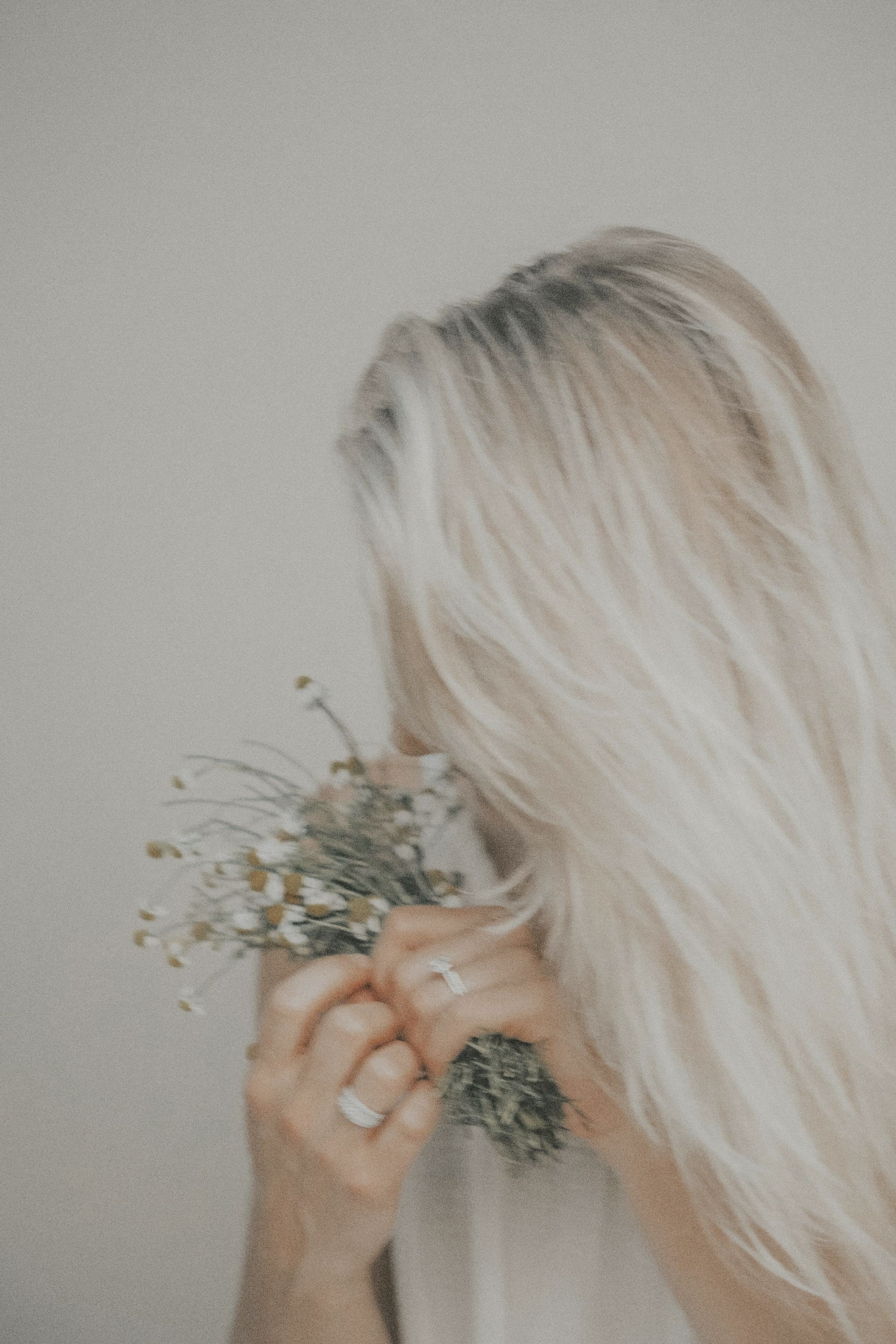 A woman holding a small bunch of dried flowers